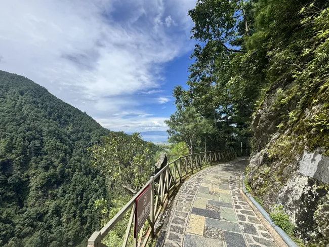 A stone path follows the mountainside.