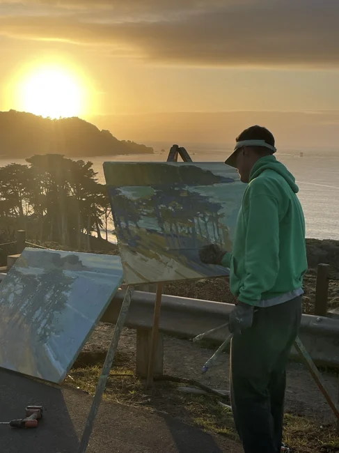 A painter catching the last light by the ocean.